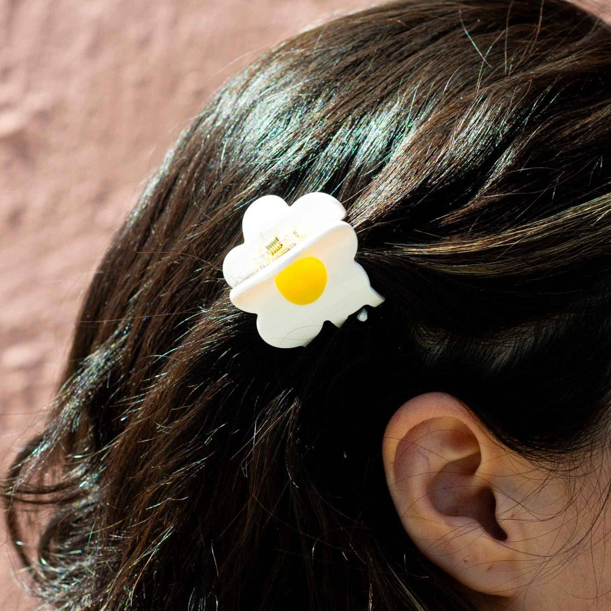 Hair clip shaped like a fried egg on a person's hair