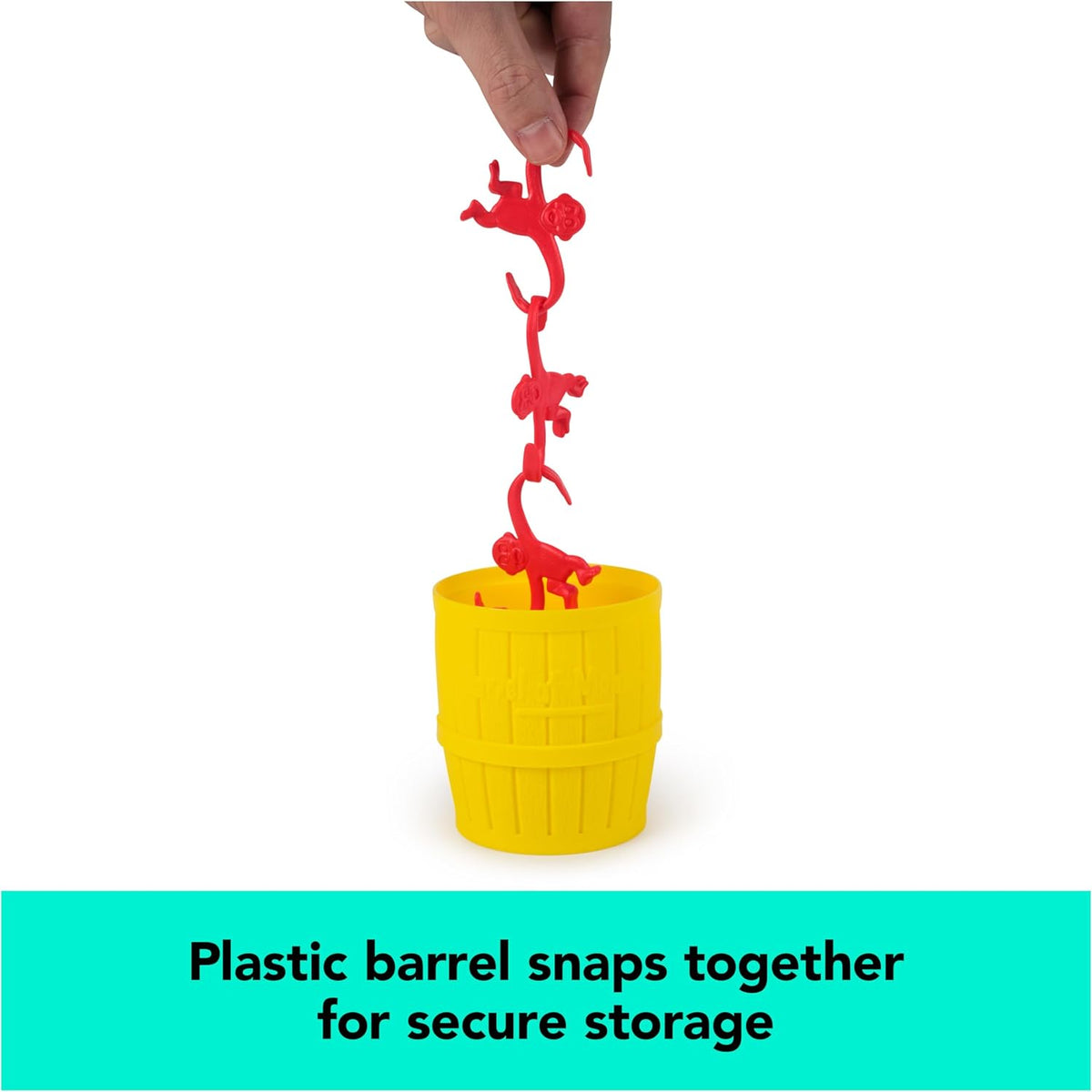 A person holding a vertical chain of red plastic monkeys suspended above a yellow plastic storage barrel for the Barrel of Monkeys Game by Continuum Games, accompanied by text reading "Plastic barrel snaps together for secure storage."