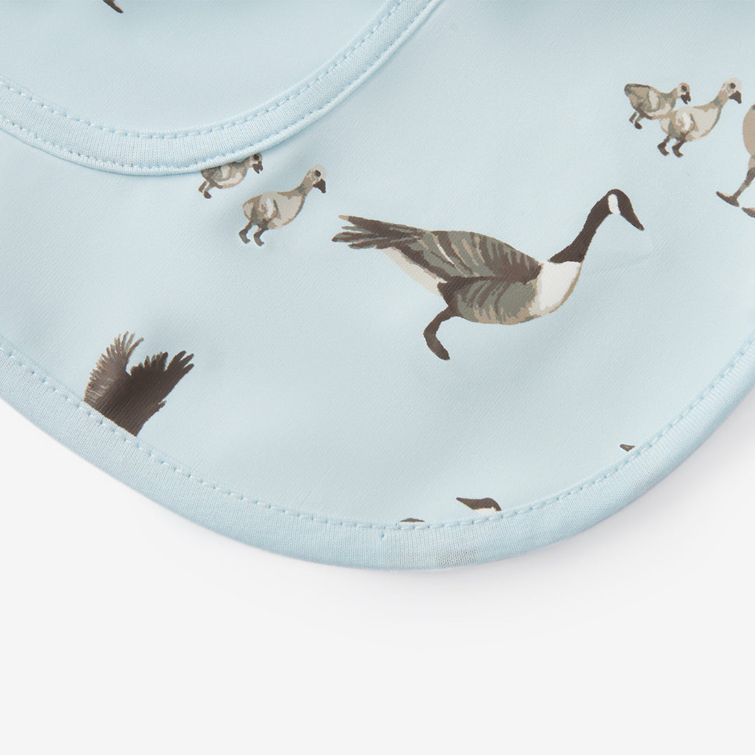 Bib with goose pattern on a light blue background