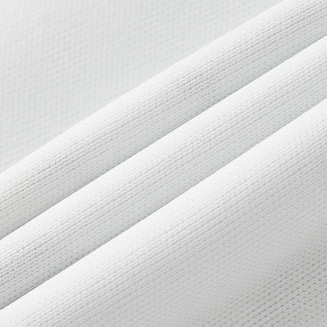 Close-up of white fabric with a textured pattern on a light gray background