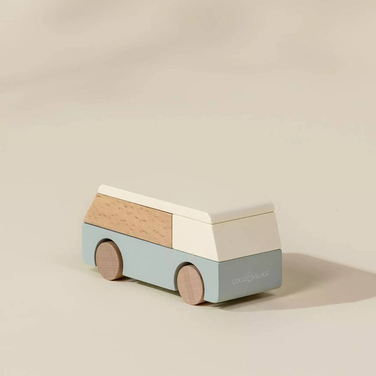 Wooden toy van with a light blue body and beige roof on a beige background