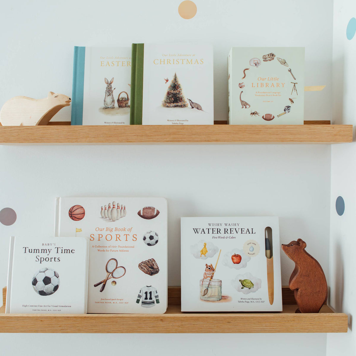 Shelf with various books and a wooden bear figurine against a light blue wall.