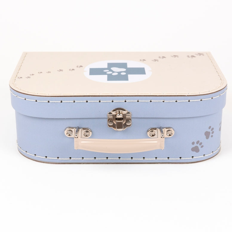A light blue and beige faux-leather storage box designed like a vintage suitcase, featuring a blue medical cross emblem on the lid, silver metal latch, and gray paw print details.