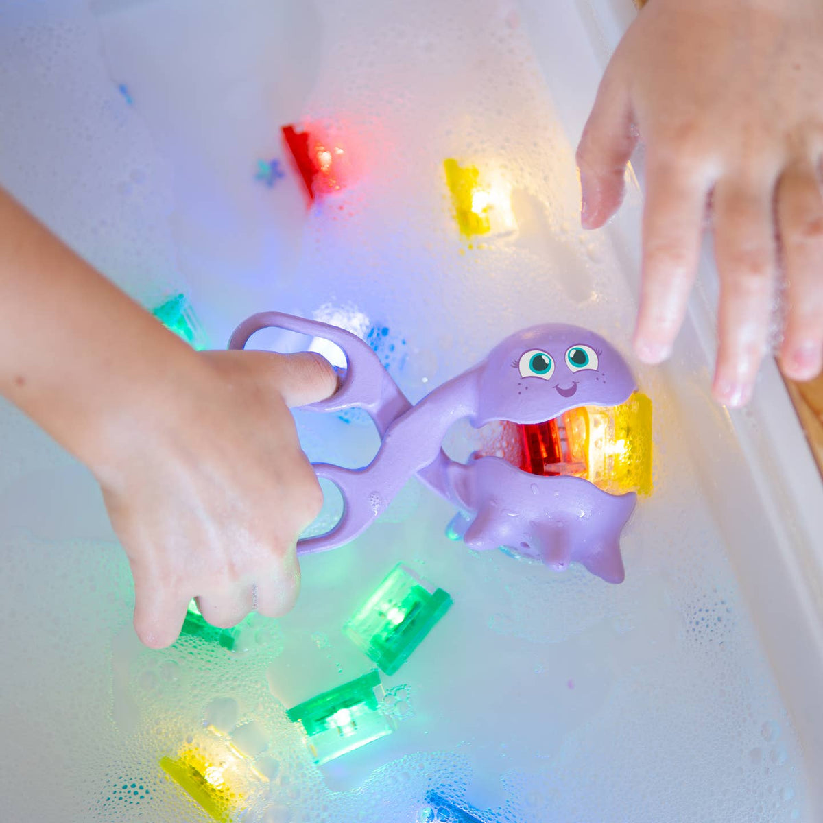 Children playing with a purple ghost toy in water, surrounded by colorful lights.