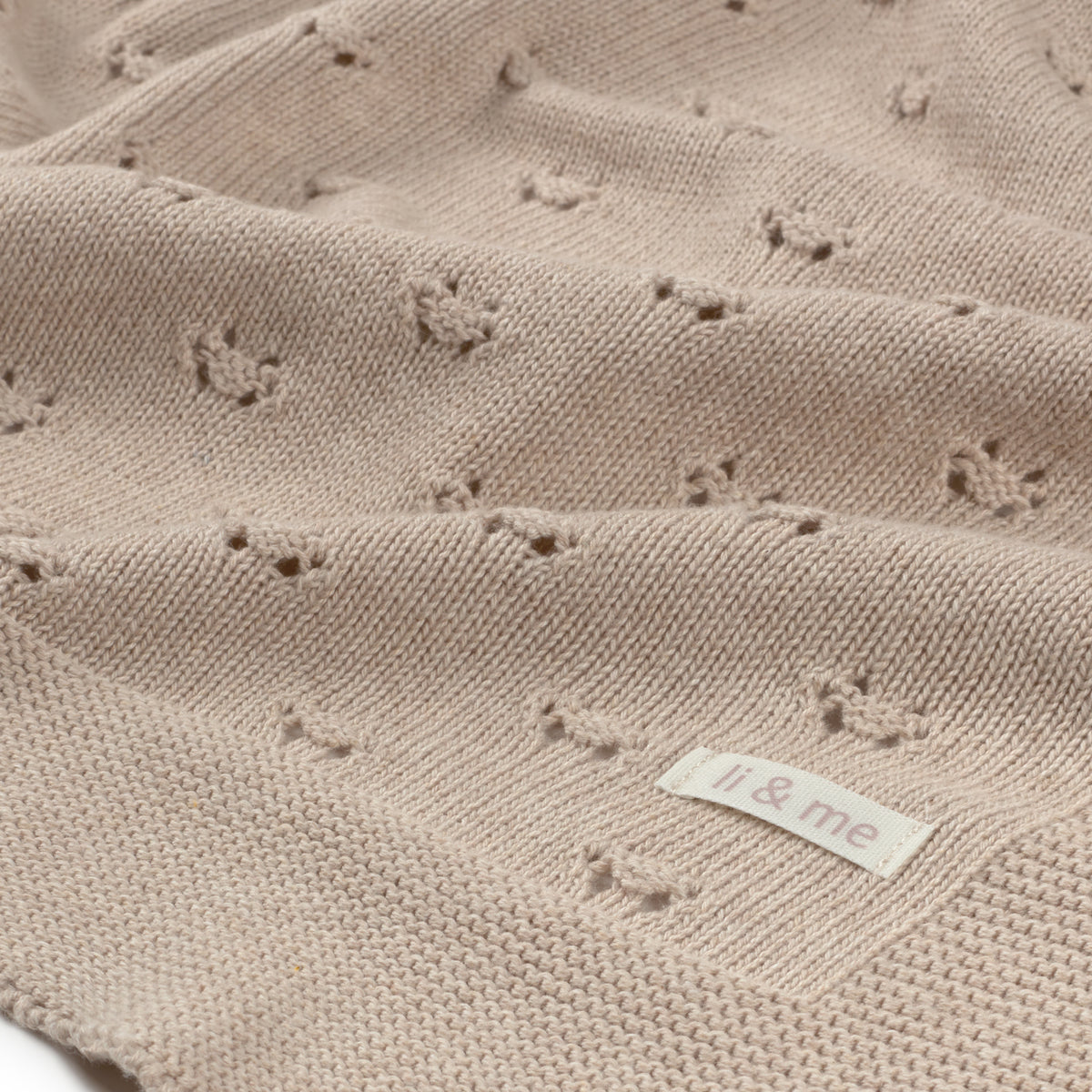 Textured beige blanket with a 'il & me' label