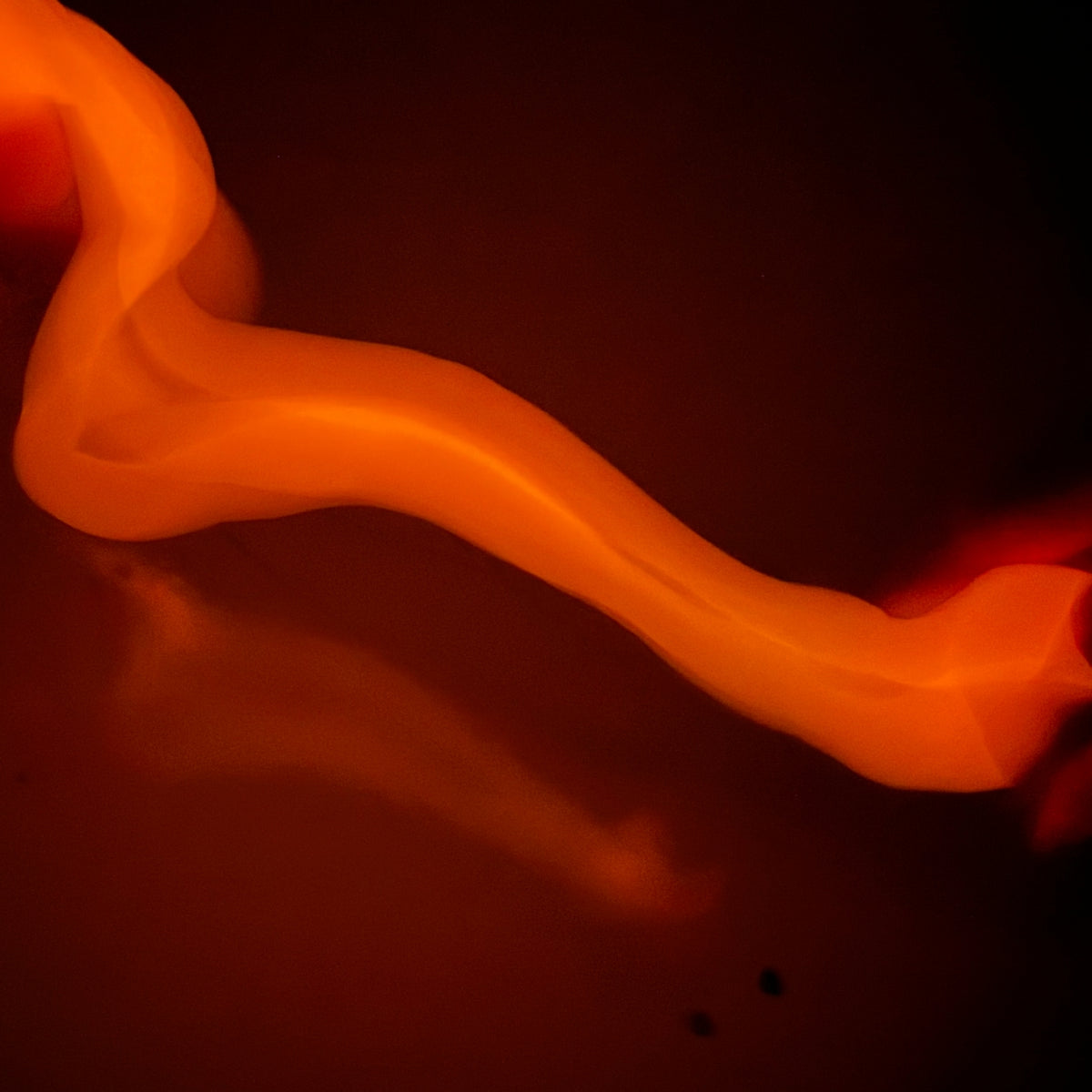 A glowing orange and red translucent ribbon or flame-like strip against a dark background.