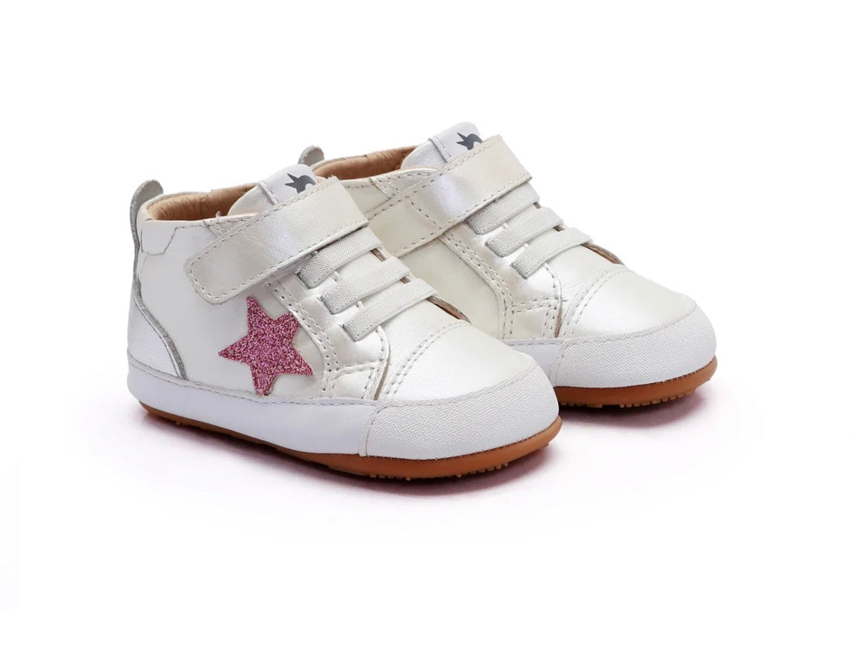 A pair of white high-top baby sneakers with silver-tone metal eyelets, hook-and-loop straps, a glittery pink star accent on the side, and brown rubber soles, shown on a white background.