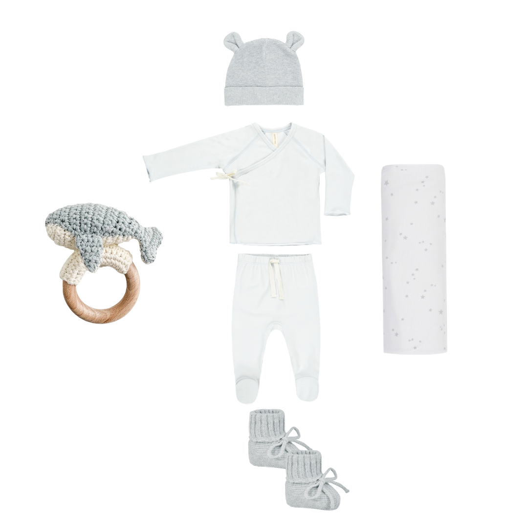 Baby clothing and accessory set including a hat, onesie, pants, booties, and a teething ring on a white background.