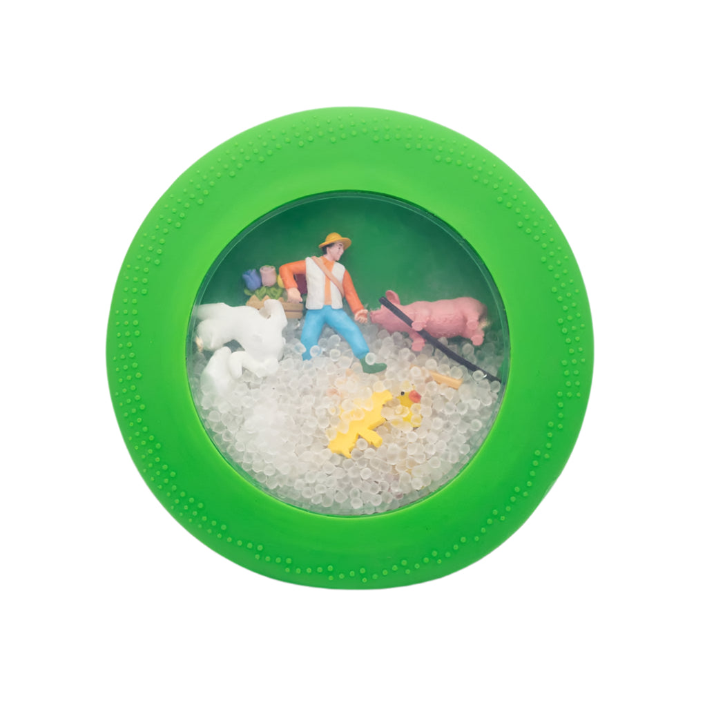 Green toy with miniature figures and animals on a white background