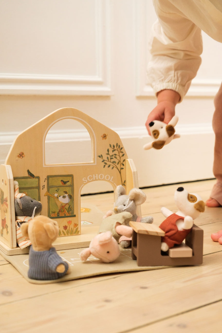 Children's wooden toy set with animal figures on a light wooden floor.