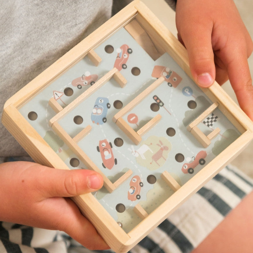 Child playing with a wooden maze toy
