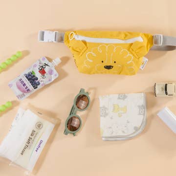 Yellow pouch with cartoon design, sunglasses, and other items on a beige background