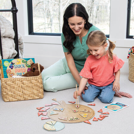 Woman and child playing with a wooden puzzle on the floor.