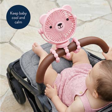 Baby in a stroller with a pink bear-shaped fan attached to the handle.