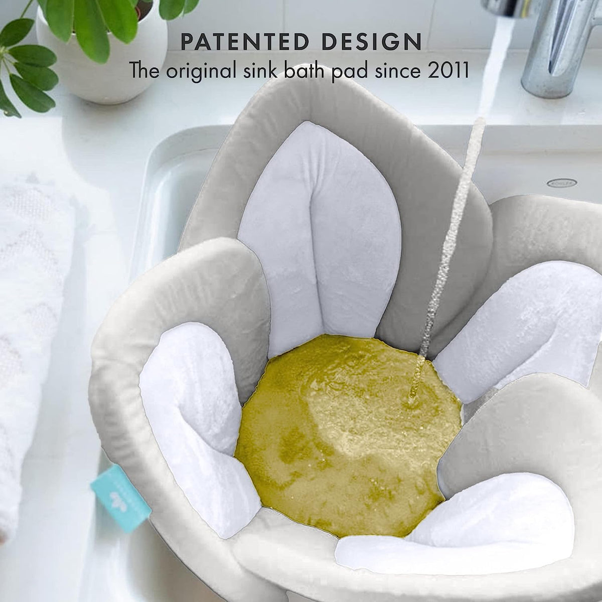Gray sink bath pad with water flowing into it, placed over a sink.