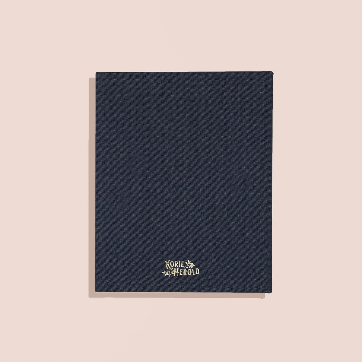Dark blue notebook with a brand logo on a beige background