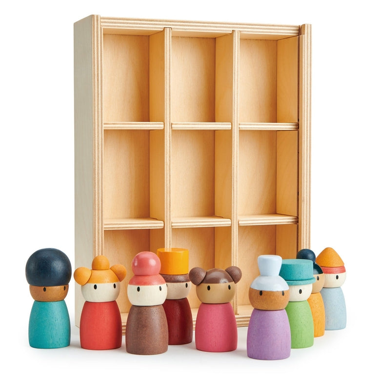Set of colorful wooden dolls in front of a wooden shelf