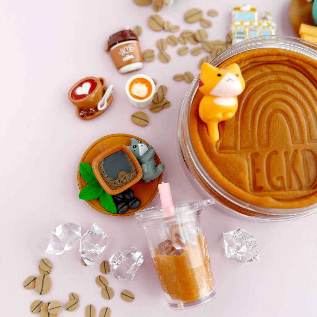 Collection of miniature food items and a jar with a bear figurine on a pink background