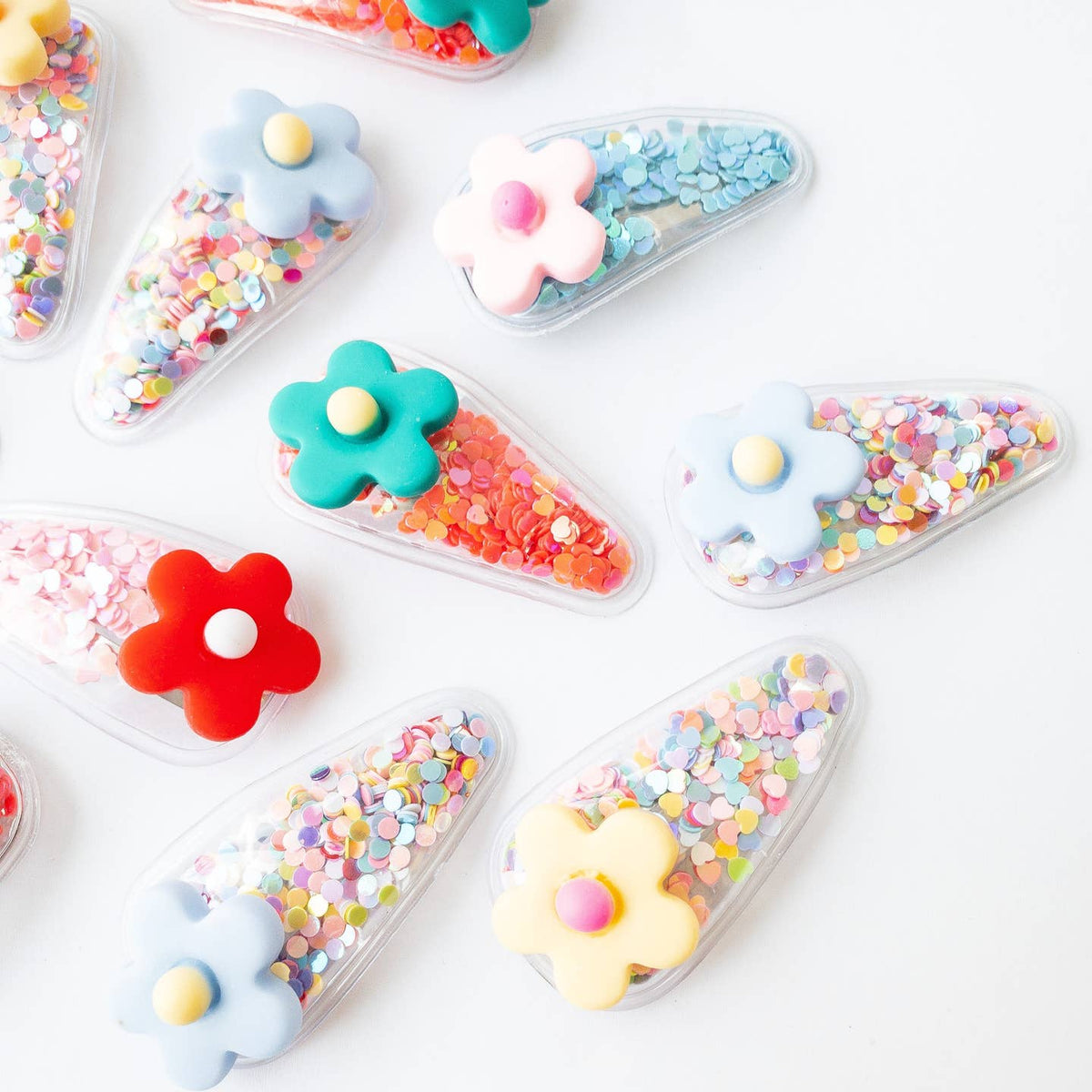 Colorful flower-shaped containers with various colorful contents on a white background