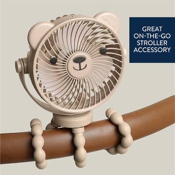 Beige fan with bear design attached to a brown handle, on a light gray background.