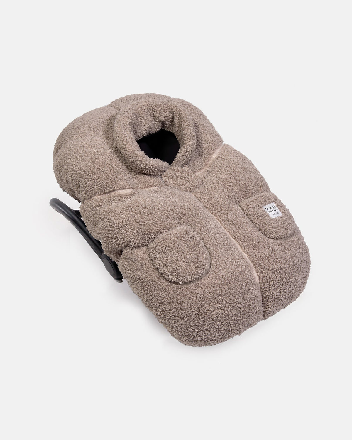 Brown fleece slippers with a brand label on a light gray background