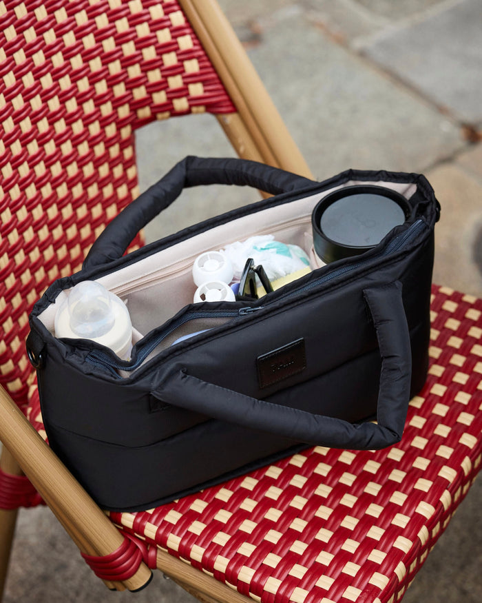 Black bag with compartments on a red and beige checkered chair