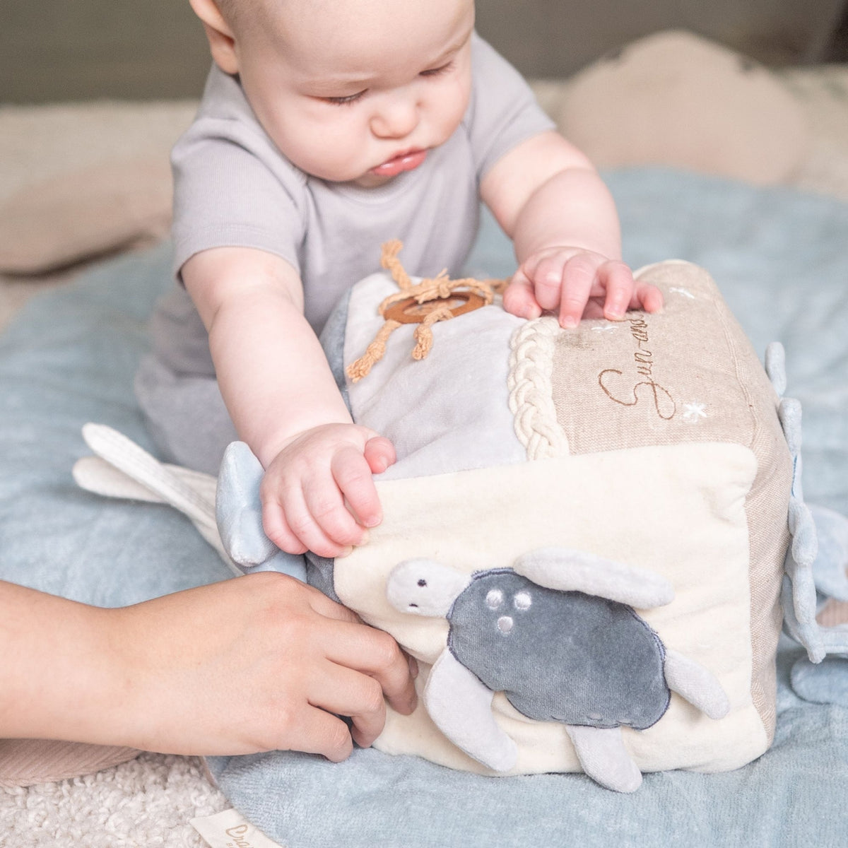 Baby playing with a plush toy on a soft surface