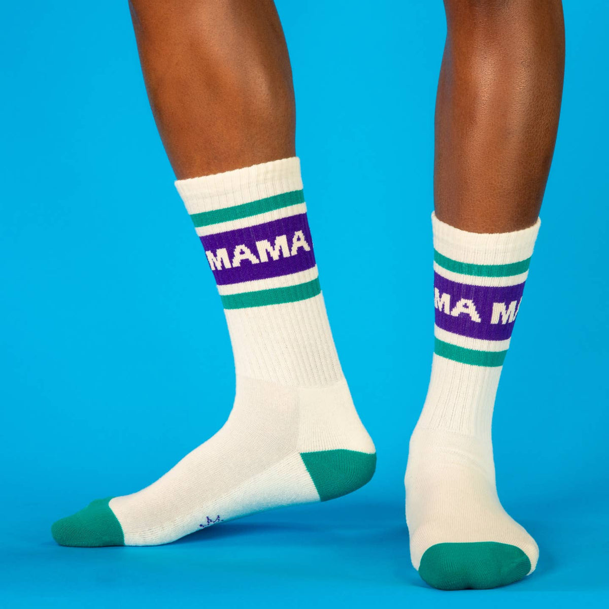White socks with purple and green stripes labeled 'MAMA' on a blue background