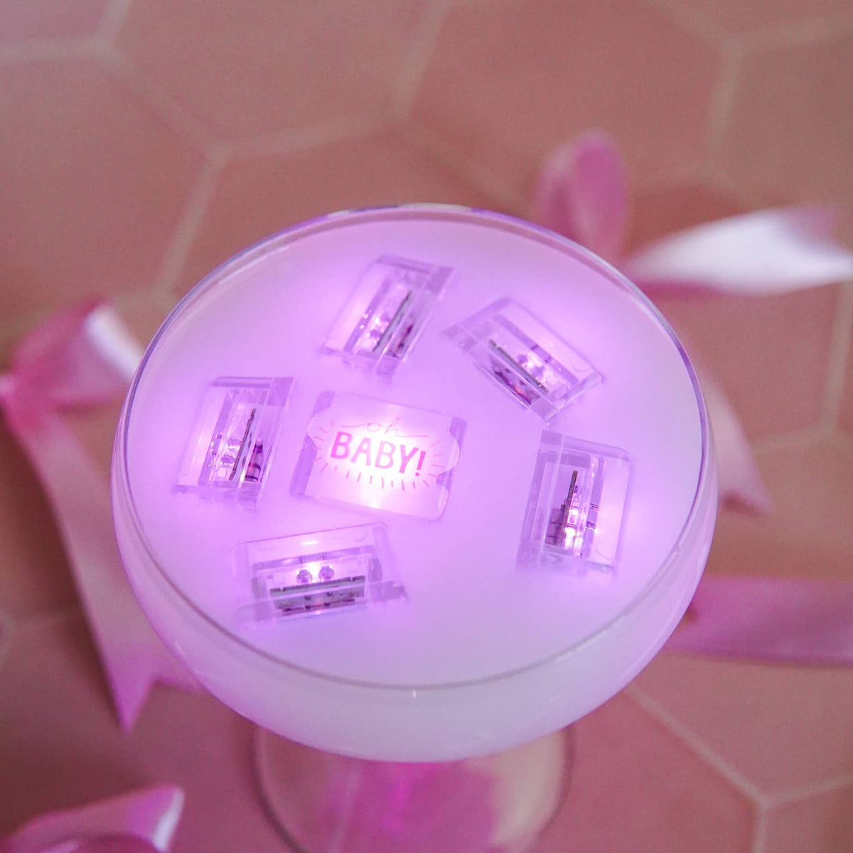 Round light bulb with 'BABY1' text on a pink background