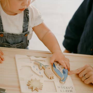 Child playing with wooden animal toys on a table
