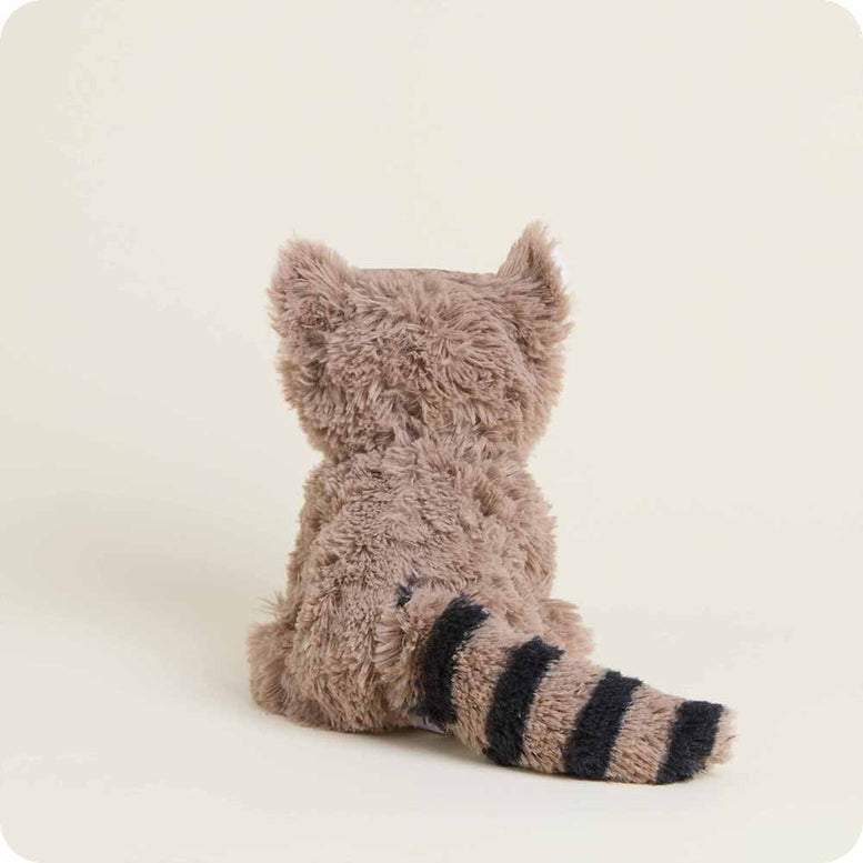 A Raccoon Junior plush toy by Warmies, featuring fuzzy brown fur, pointed ears, and a striped tail, shown from behind in a sitting position.