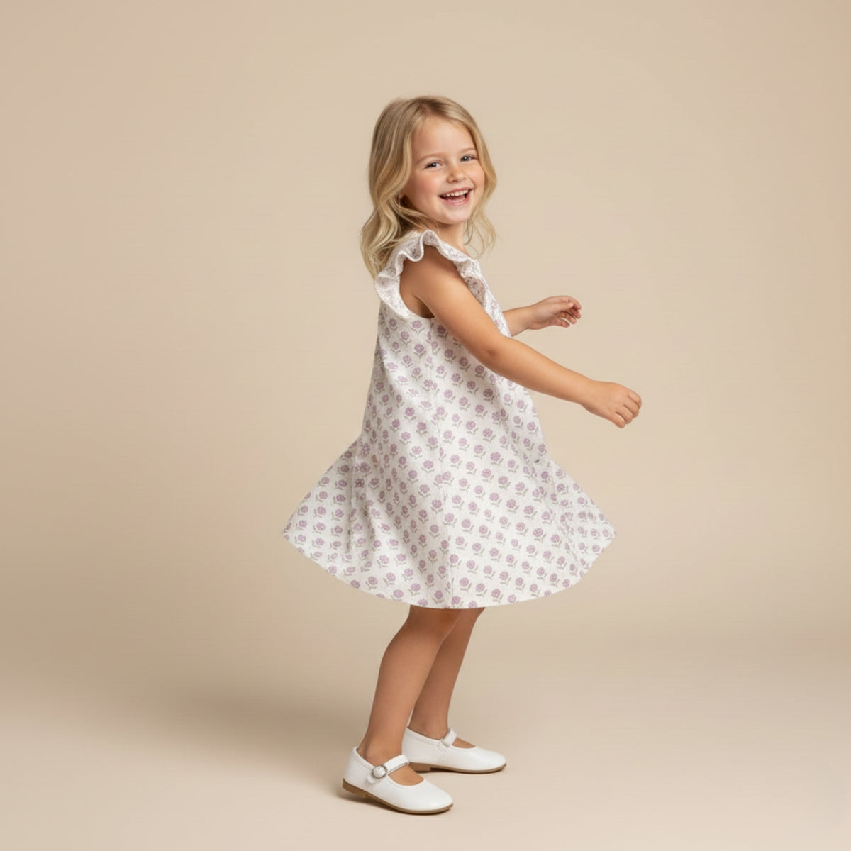 Young girl wearing a white dress with a floral pattern on a beige background