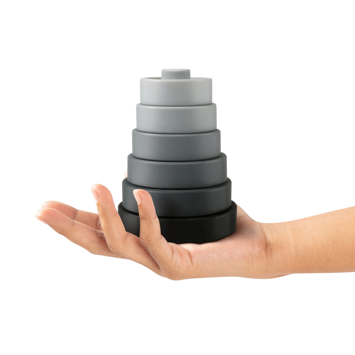 Stack of gray silicone coasters held in a hand on a white background