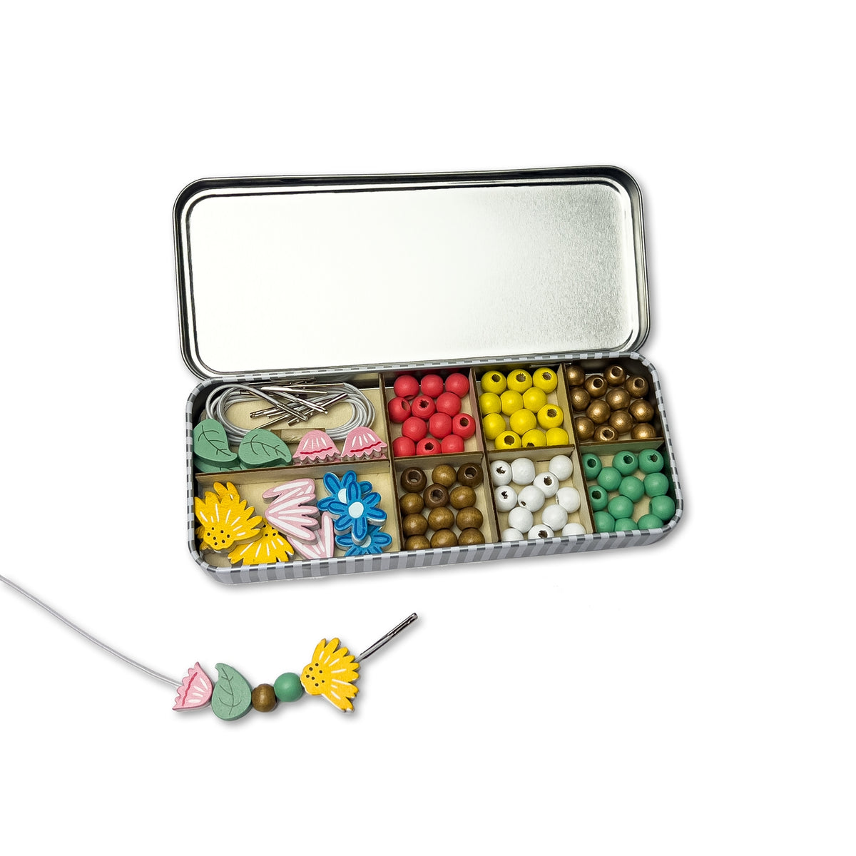Beads and jewelry-making tools in a metal case on a white background