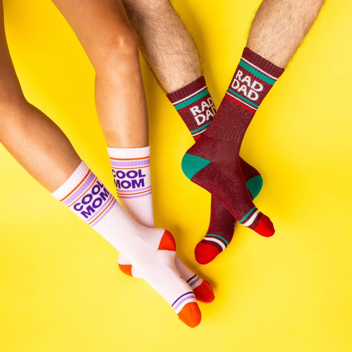 Two pairs of colorful socks with text on a yellow background