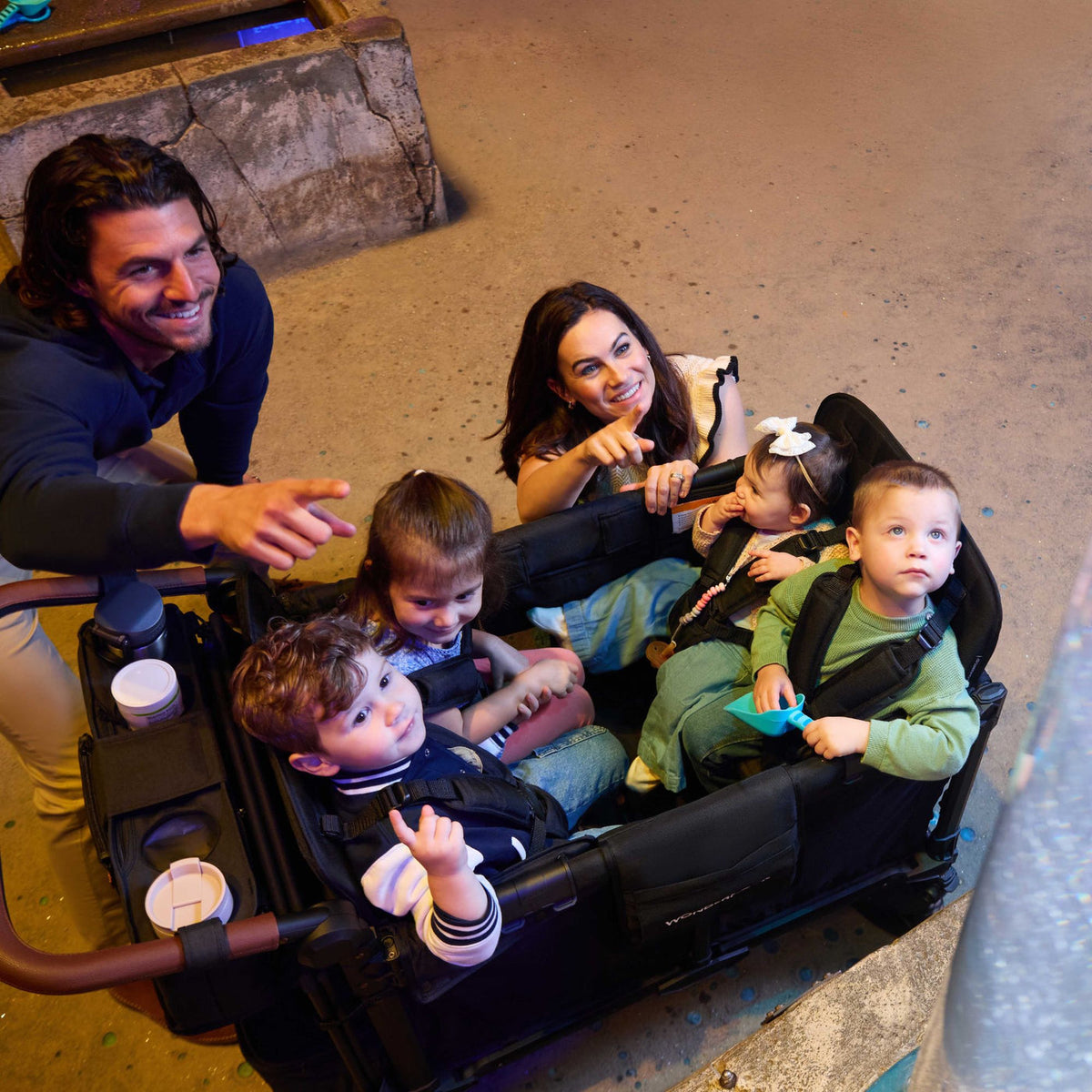 Family with four children in a stroller on a ride at an amusement park.