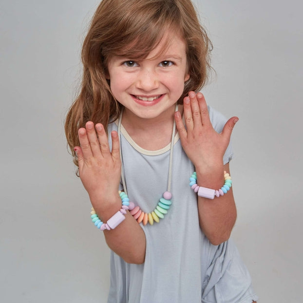 Young girl in a light blue dress posing against a plain background
