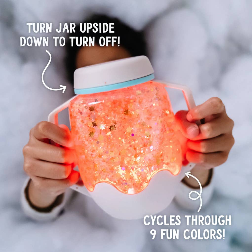 Person holding a glowing pink jar with text indicating how to turn it on and off, and cycle through colors.