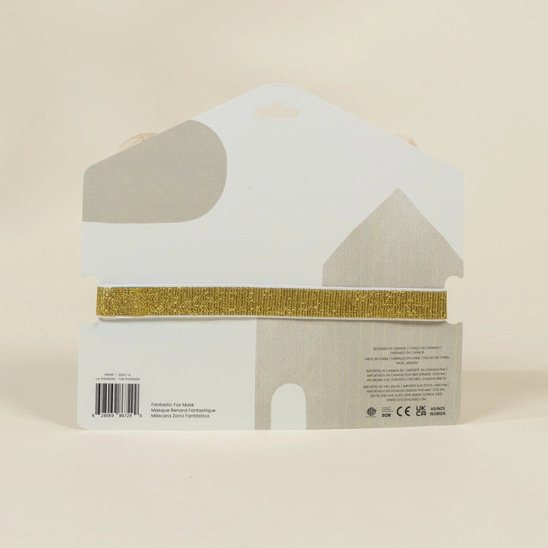 A packaged decorative item in a white house-shaped box with a gold glitter horizontal band across the middle, photographed against a plain warm beige background.