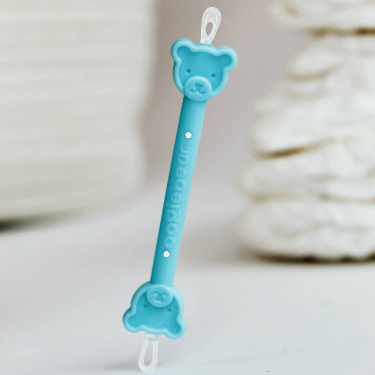 Blue bear-shaped pacifier clip on a white background
