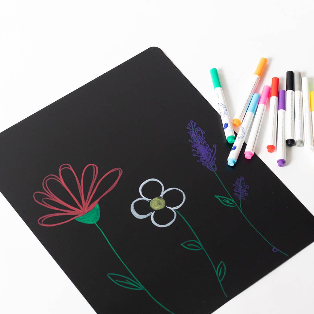 Black board with colorful flower drawings and markers on a white background