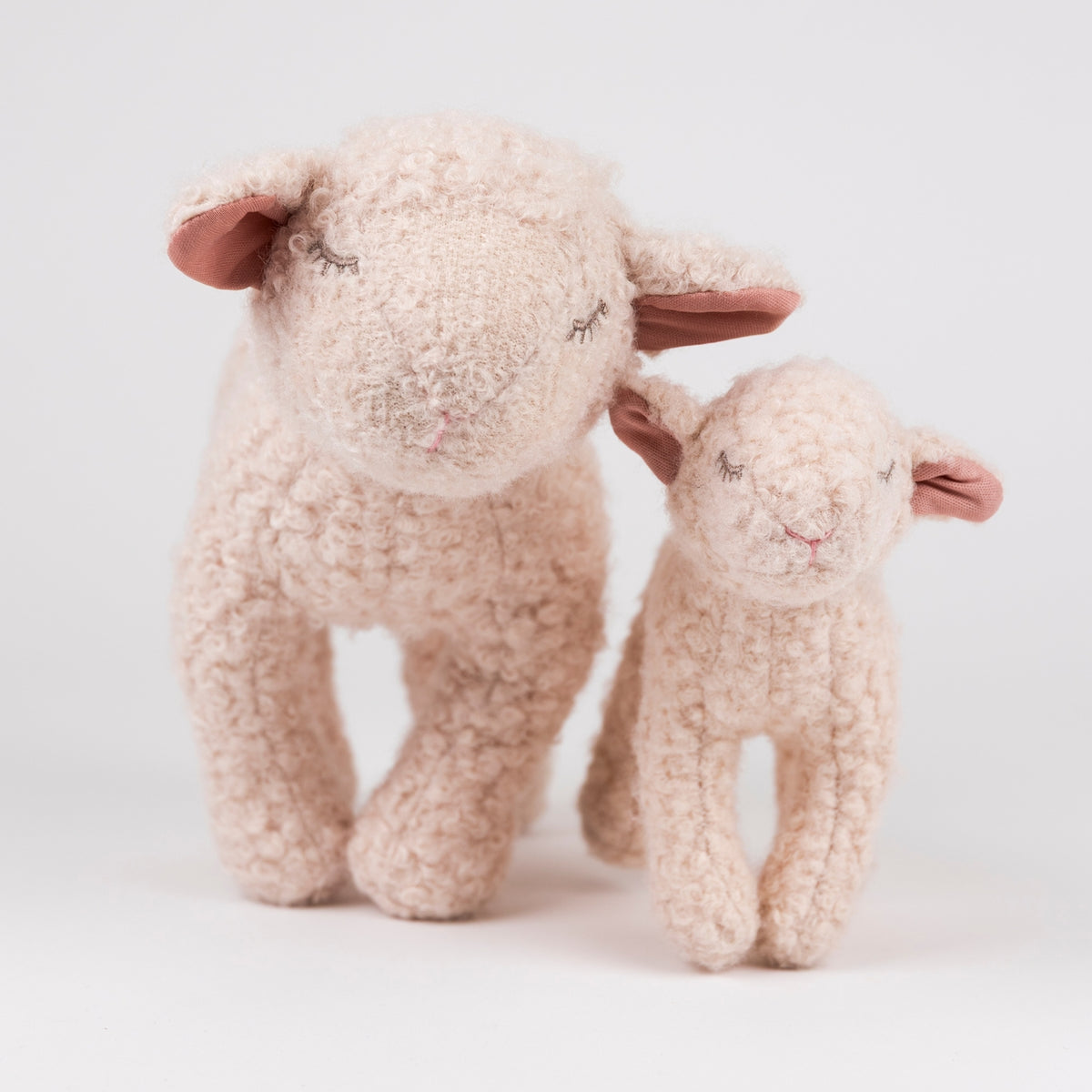 Two fluffy toy sheep on a light background