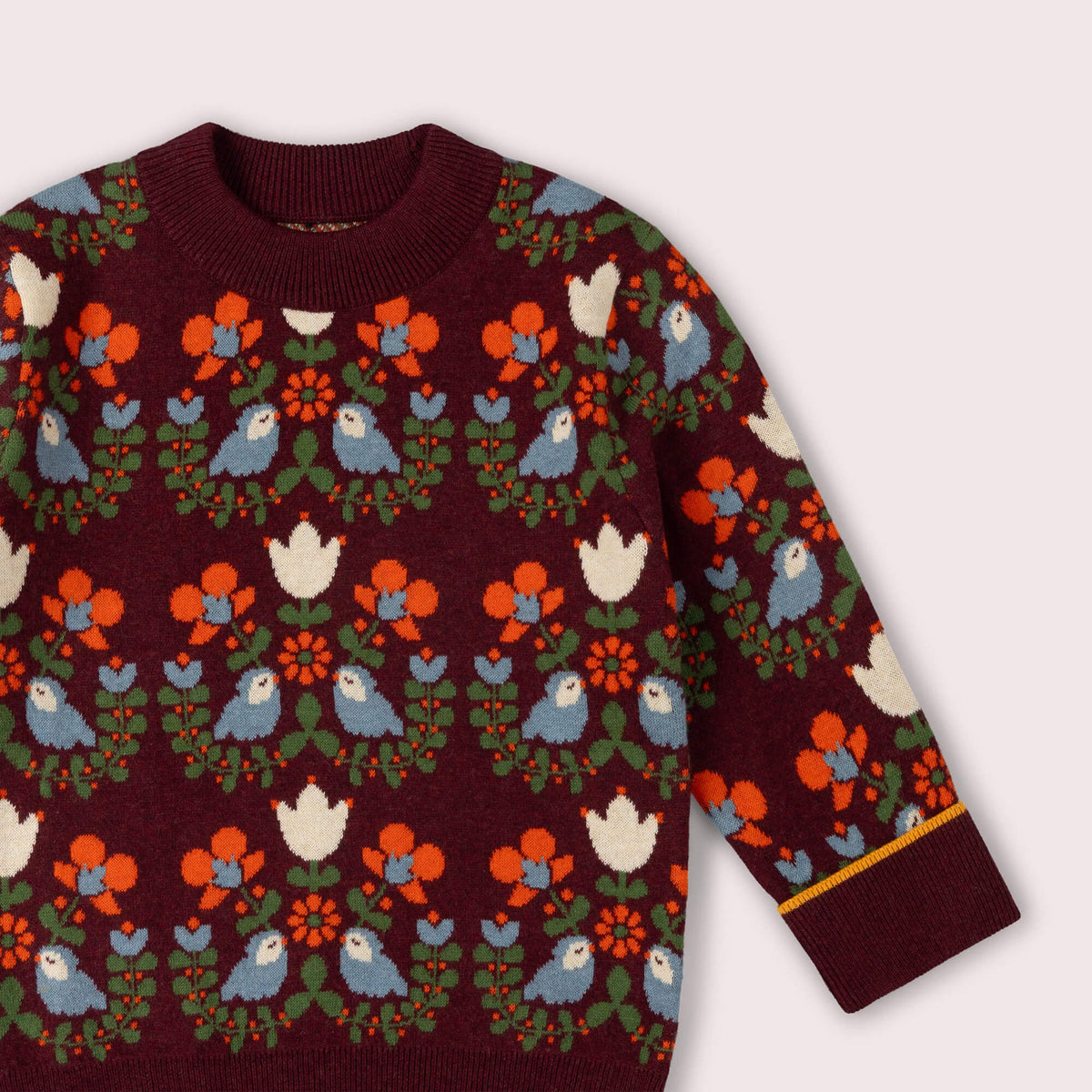 Maroon sweater with colorful bird and floral pattern on a white background
