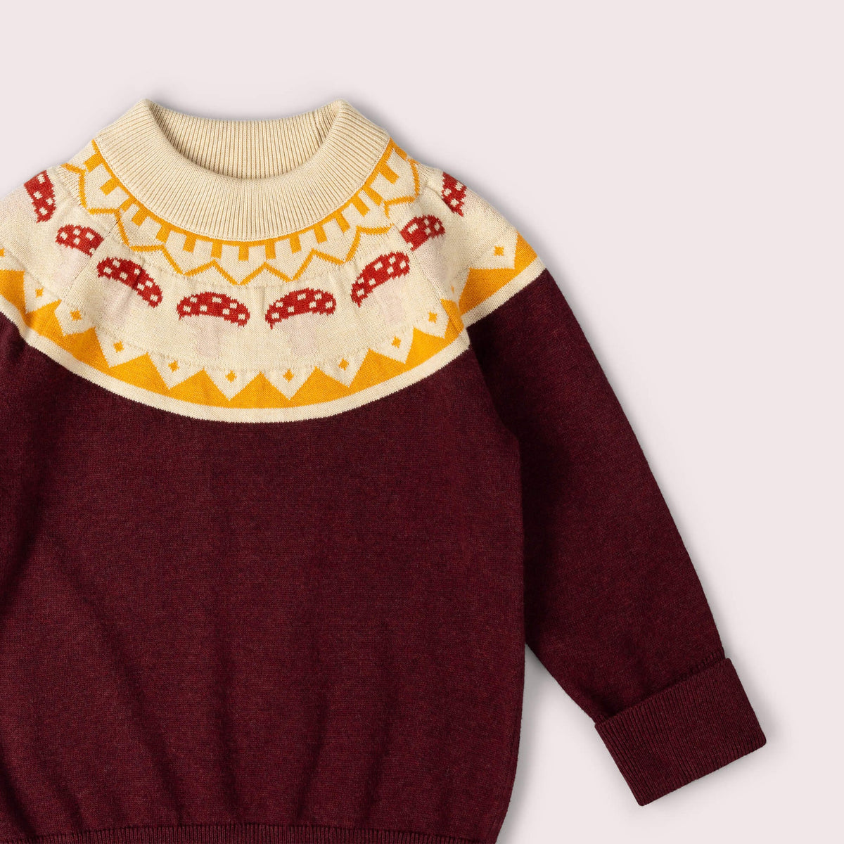 Maroon sweater with a colorful patterned collar on a light gray background