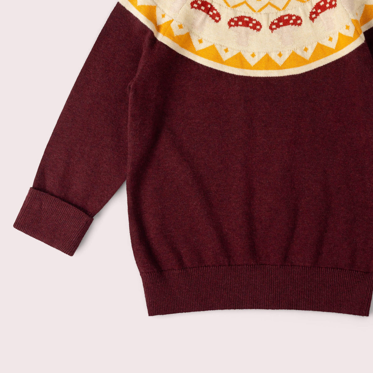Maroon sweater with a colorful patterned collar on a light gray background