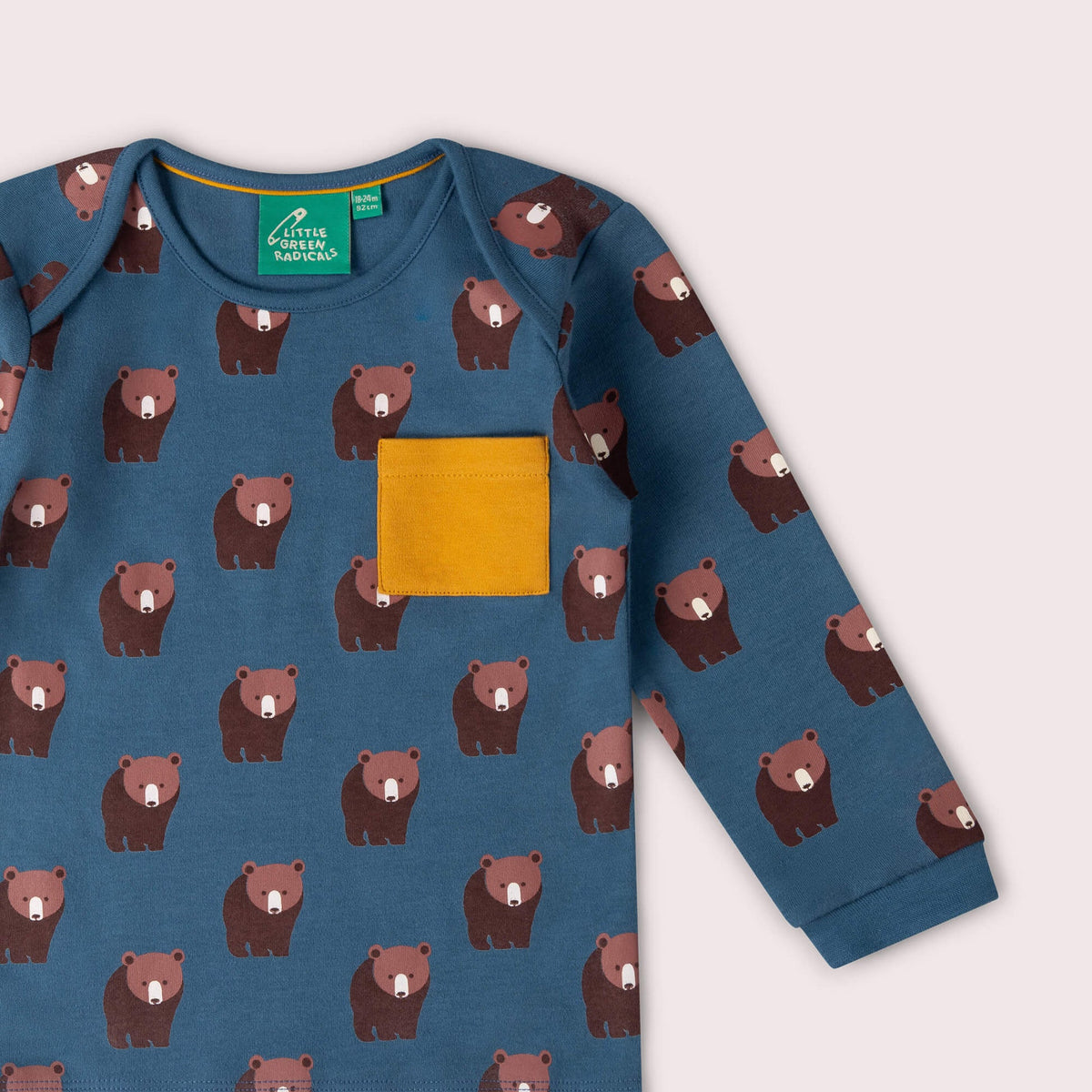A long-sleeve shirt with bear pattern and yellow pocket on a light gray background