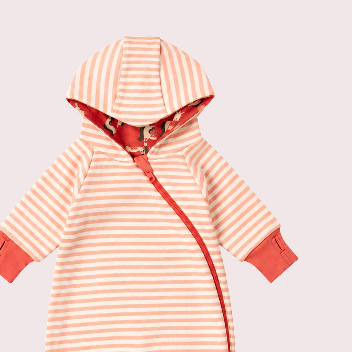 A baby long-sleeve footless romper with horizontal peach and white stripes, featuring solid peach cuffs and a peach side zipper, shown on a light pink background.