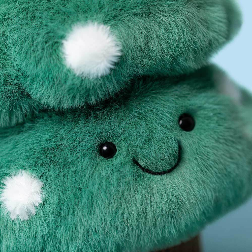 Close-up of a green plush toy with white spots and black eyes.