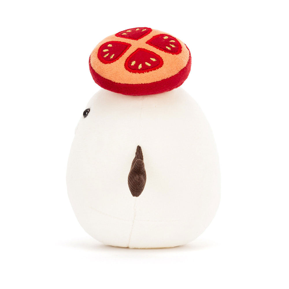 Plush toy resembling a white creature with a red and orange slice on its head against a white background
