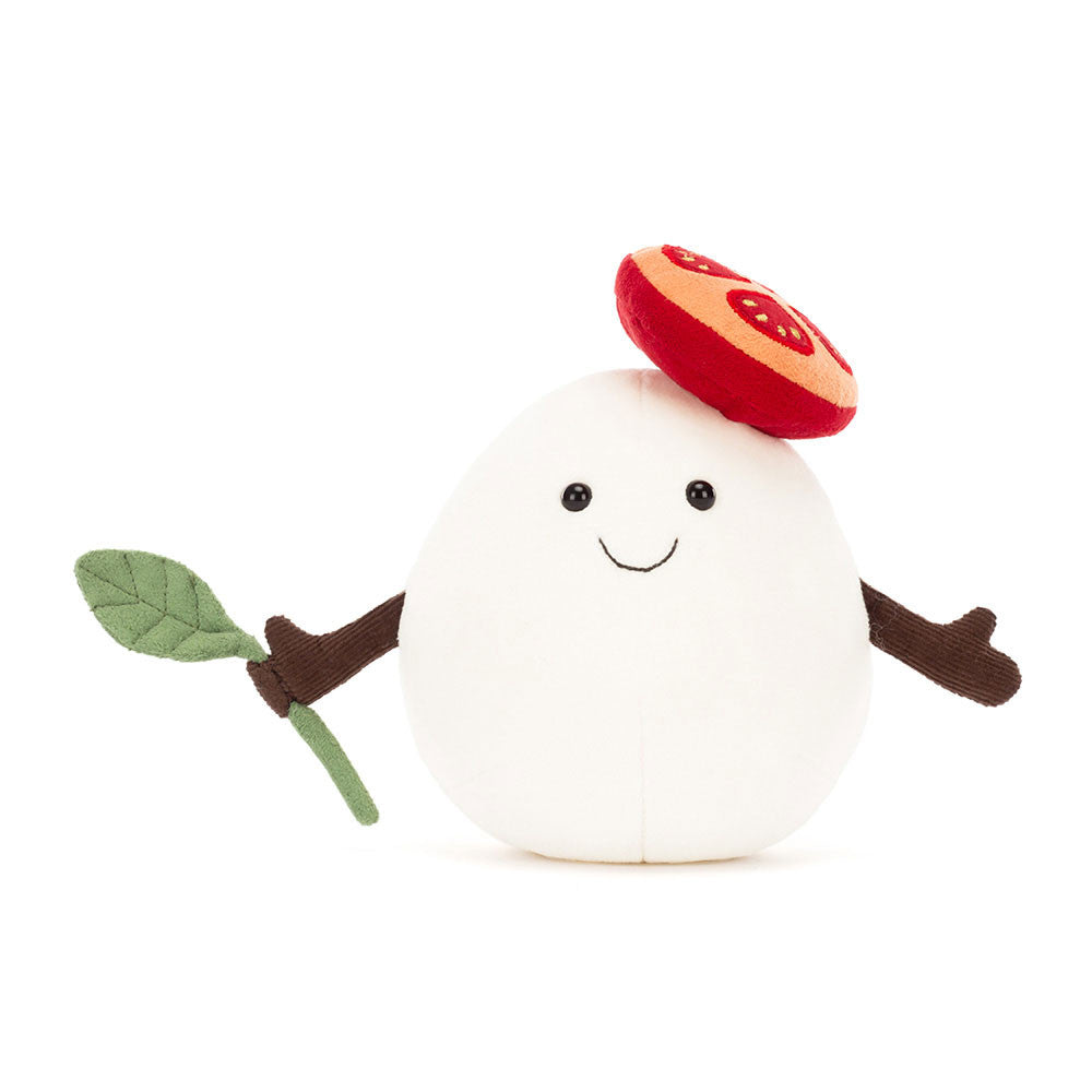 Plush toy resembling a white mushroom with a red cap and green leaf on a white background